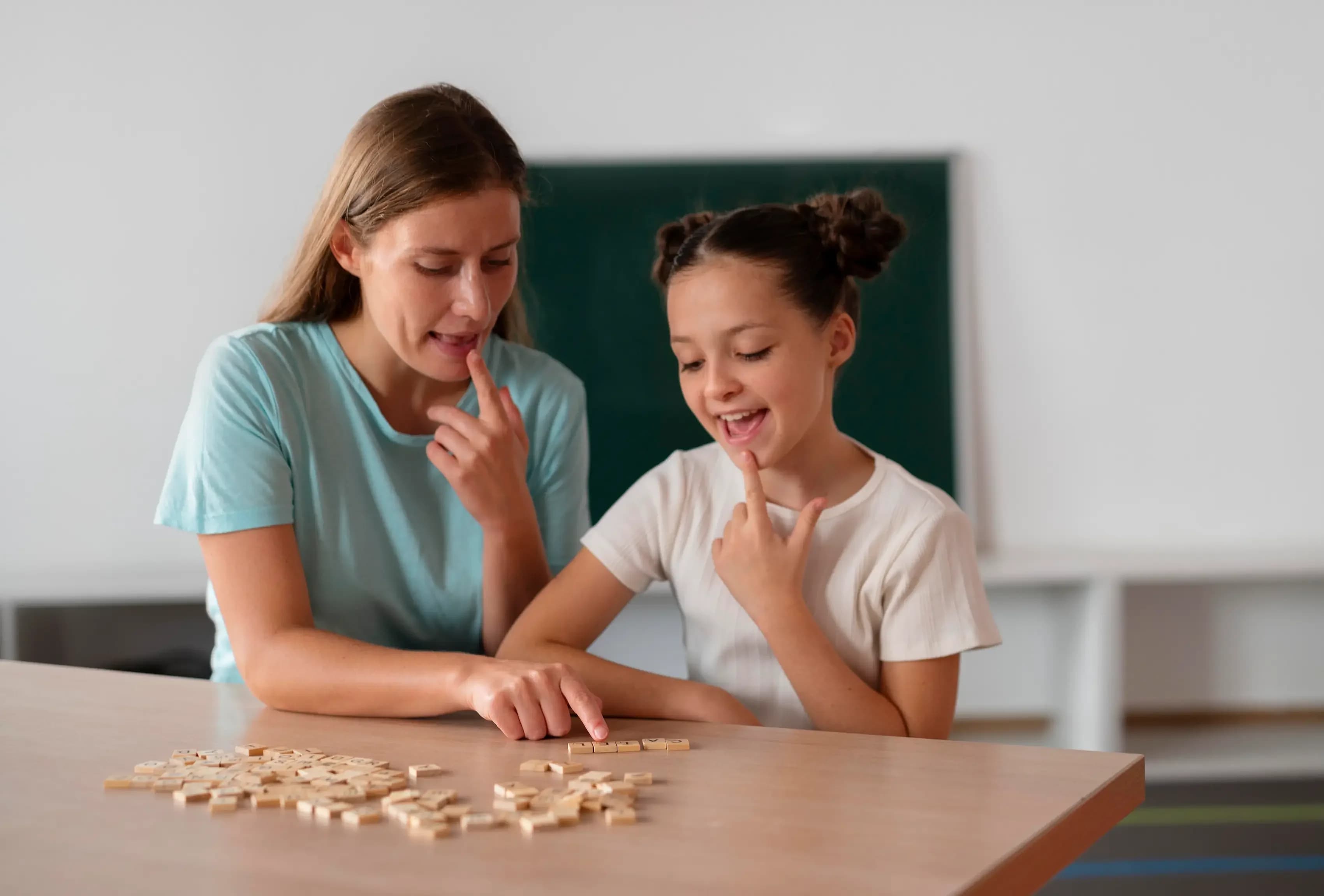 Logopeda realizando ejercicios de articulación para tratar la dislalia en niños con apoyo de materiales visuales.